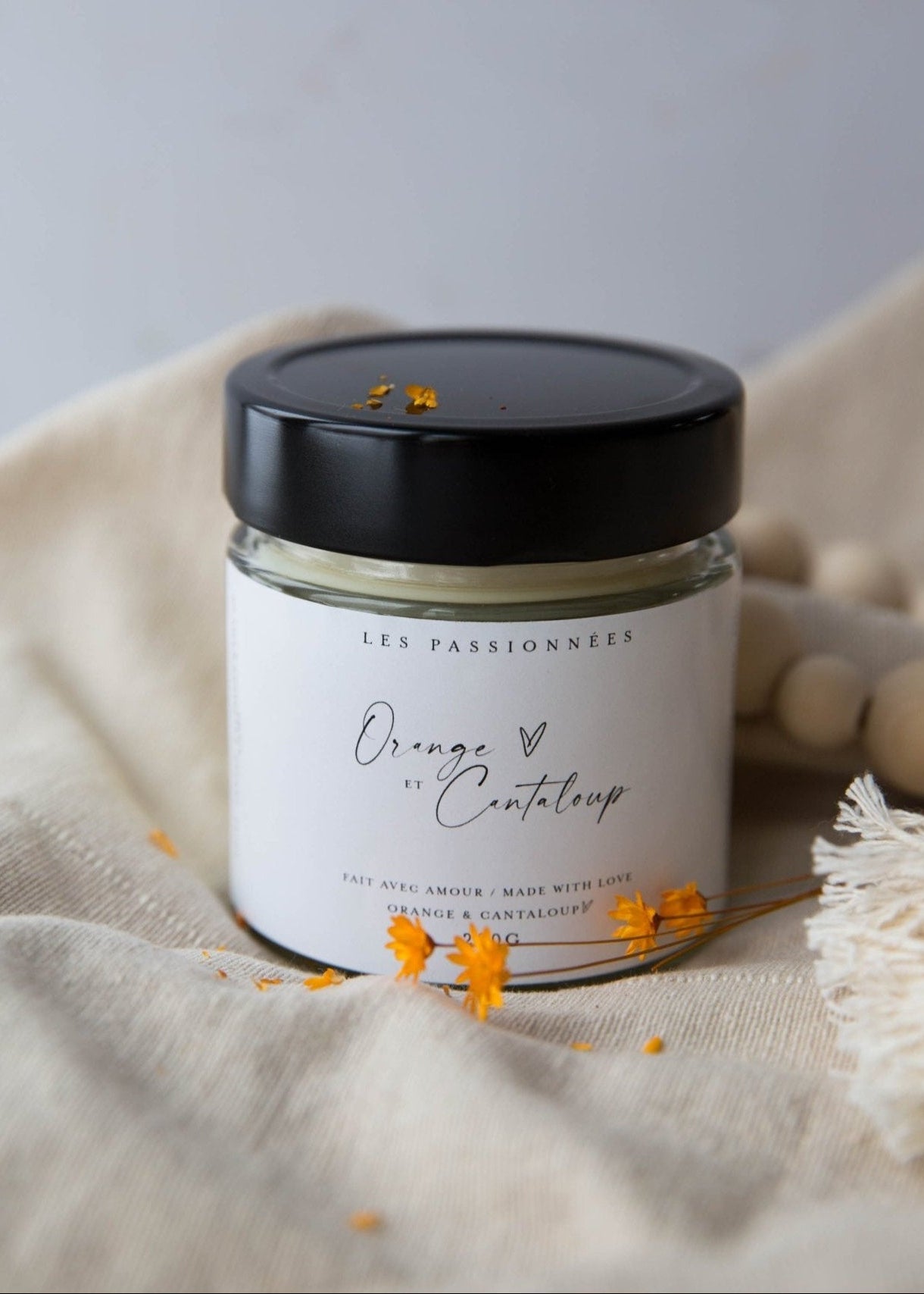 Chandelle artisanale en cire de soya et noix de coco parfum Orange et Cantaloup dans un decor naturel