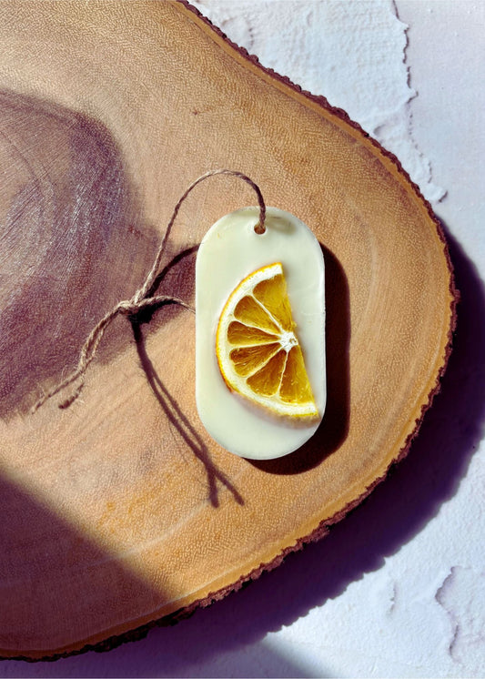 Tablette de cire parfumée Citron et Baies avec tranche d’agrume séchée posée sur un support en bois naturel pour parfumer les petits espaces
