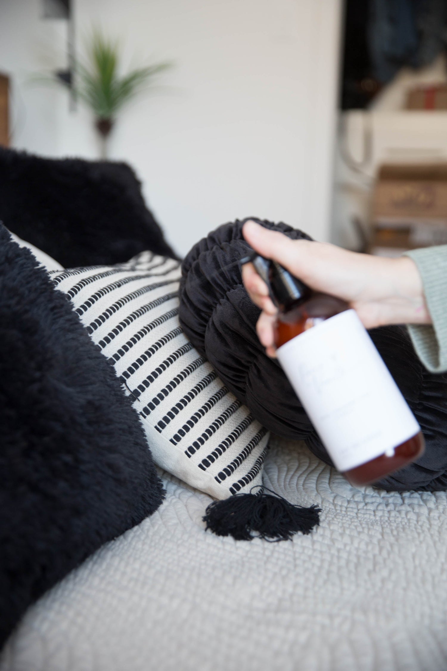 Eau de linge parfumée vaporisée sur des coussins pour créer une ambiance douce et apaisante à la maison