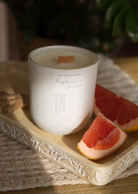 Chandelle parfumée pamplemousse et gingembre avec quartiers de pamplemousse sur plateau en bois