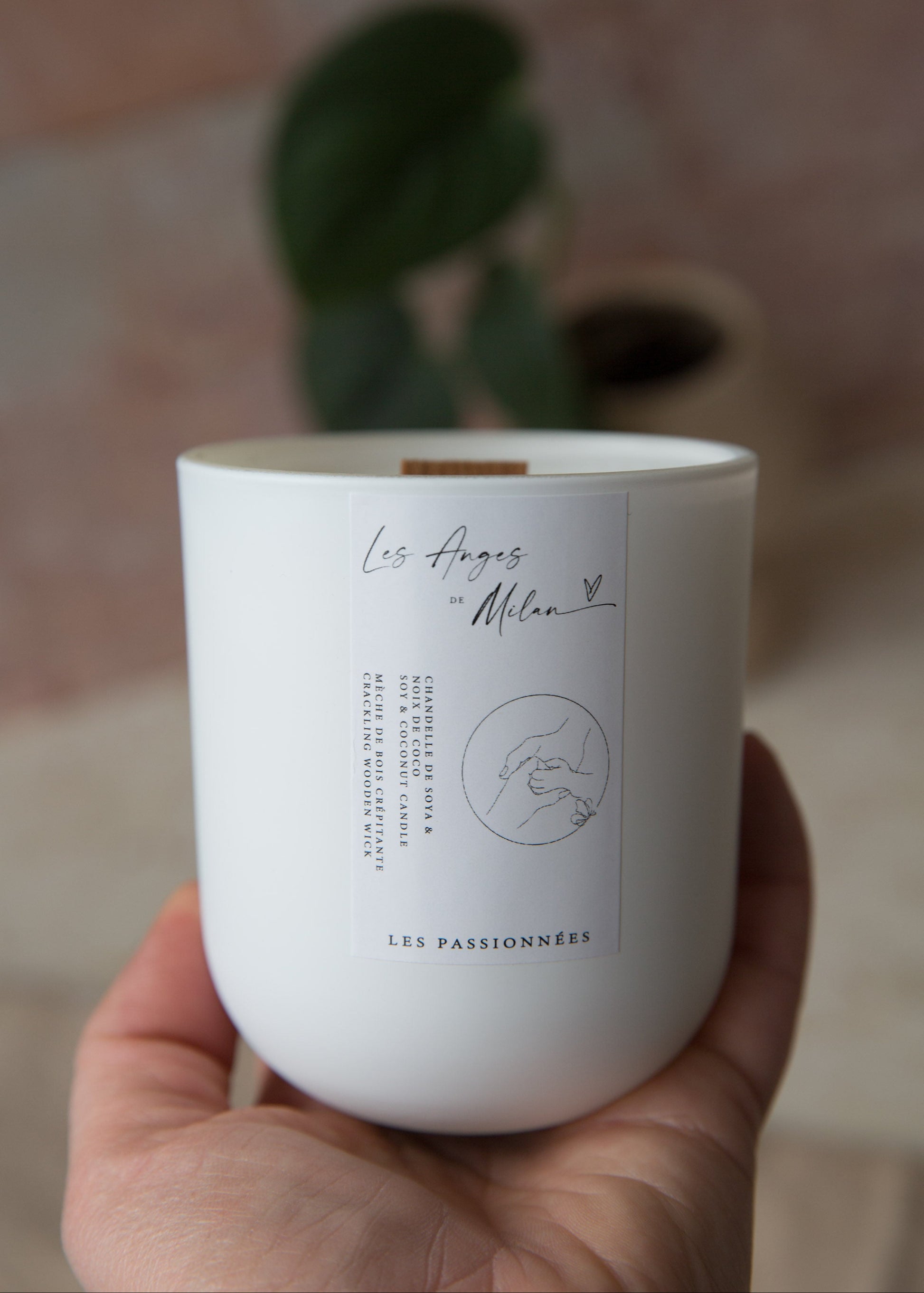 Chandelle blanche tenue dans la main, création québécoise en hommage à Milan avec profits remis à la fondation Les Anges de Milan