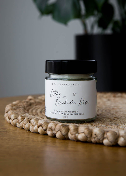 Bougie parfumee litchi et orchidee rose sur plateau en osier decor interieur minimaliste