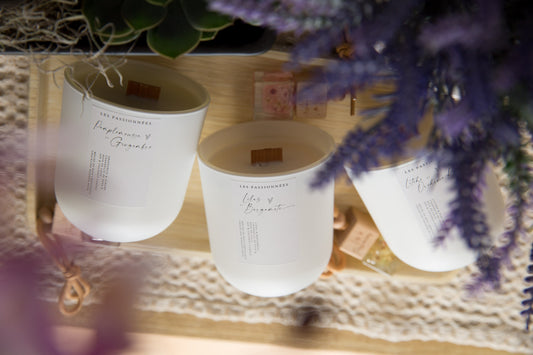 Chandelle parfumée de la collection Printemps avec fleurs mauves et décor naturel lumineux