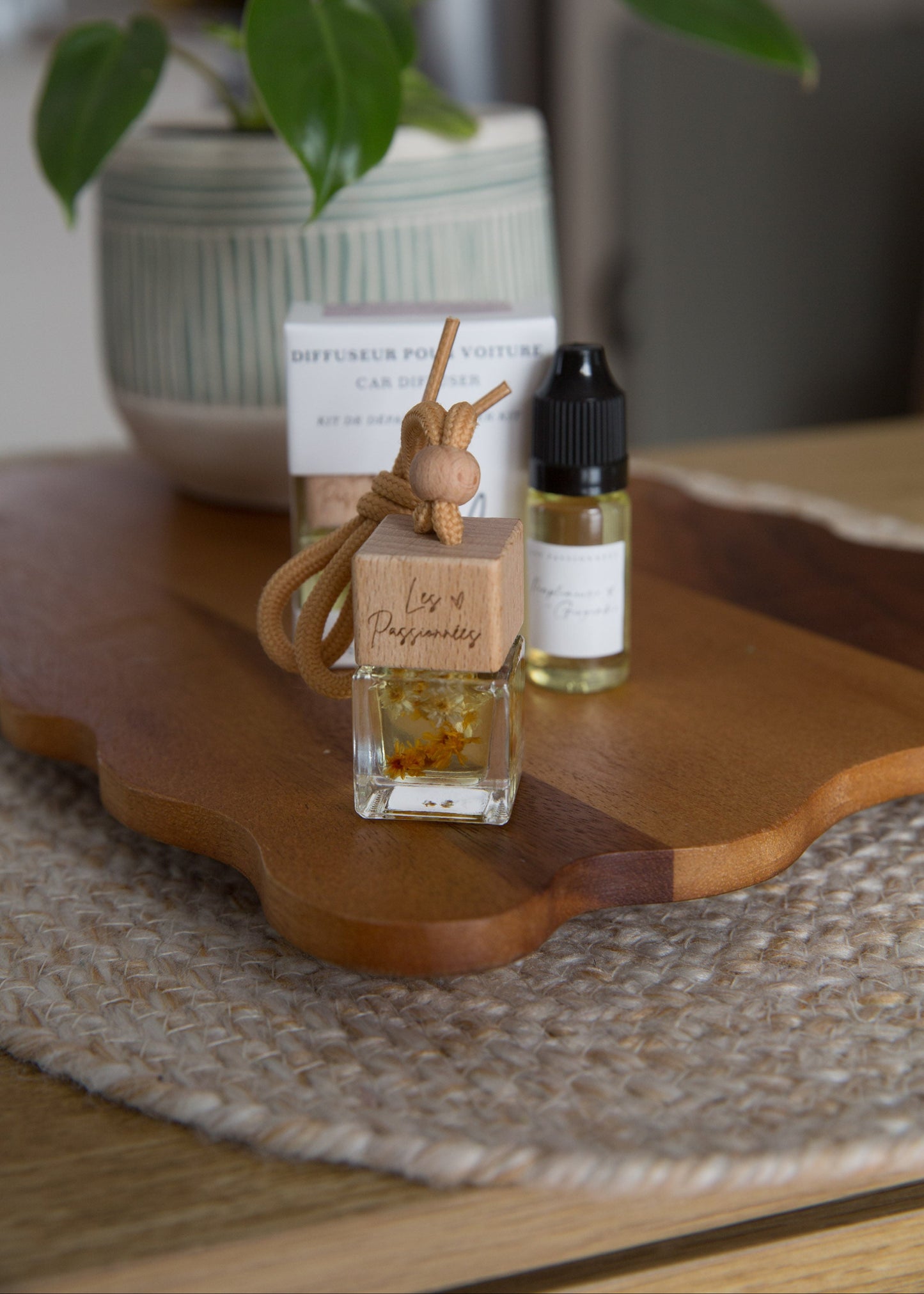 Diffuseur à voiture parfumé pamplemousse et gingembre posé sur table avec plante et décor naturel
