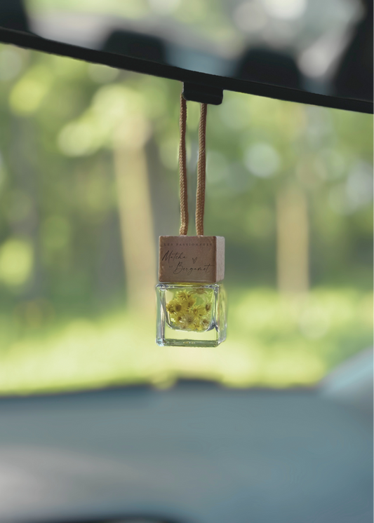 Diffuseur à voiture pamplemousse et gingembre suspendu au rétroviseur dans une voiture