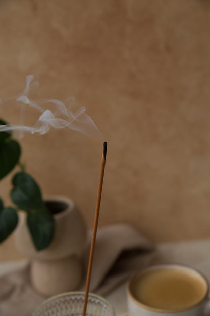 Encens parfumé Framboise et Pin dans une ambiance cosy avec tasse et plante, parfum chaleureux pour la maison