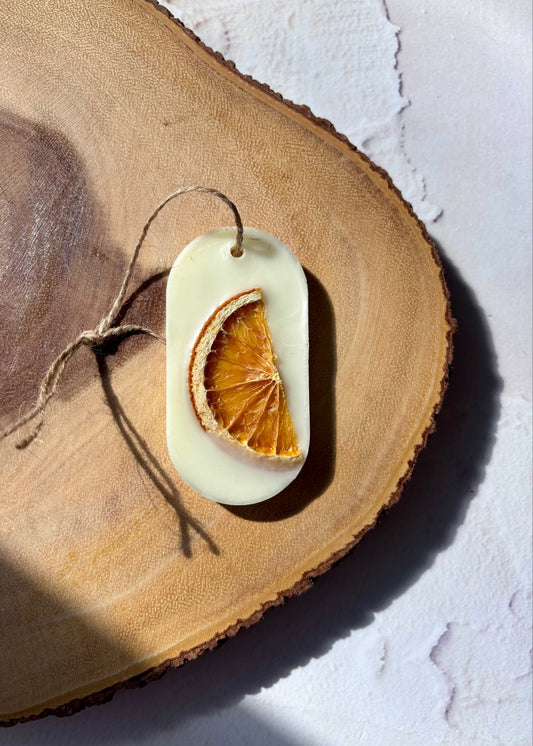Tablette de cire parfumée Orange et Cantaloup avec tranche d’agrume séchée posée sur support en bois naturel pour parfumer les petits espaces